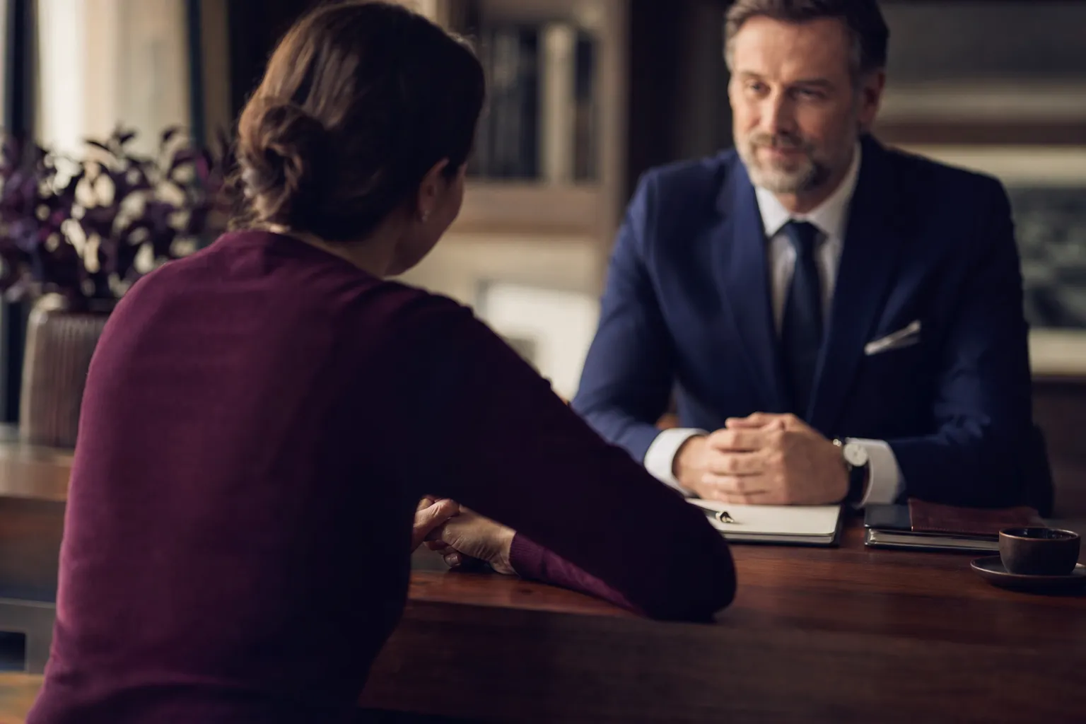 A reassuring bonding advisor across a table from a relieved client